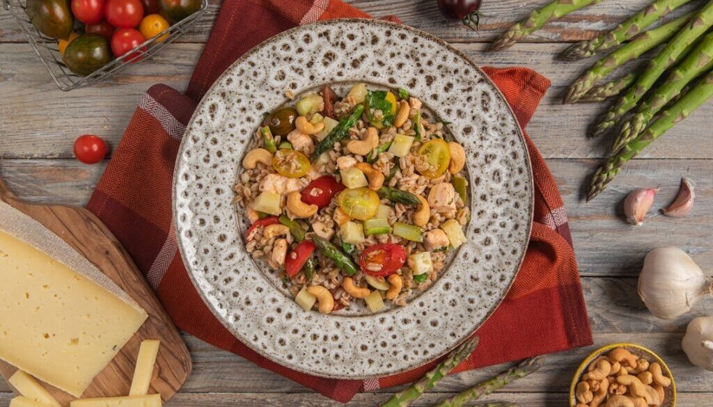 Insalata di farro con salmone, pomodorini, asparagi, anacardi e Casera