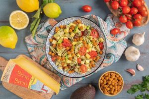 Insalata di pasta con emulsione alle erbe, pomodorini, avocado, ceci croccanti, olive e bitto dop
